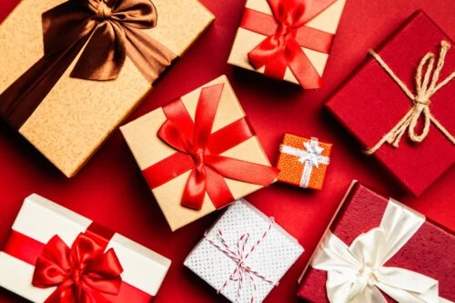 Cajas de regalo variadas sobre superficie roja