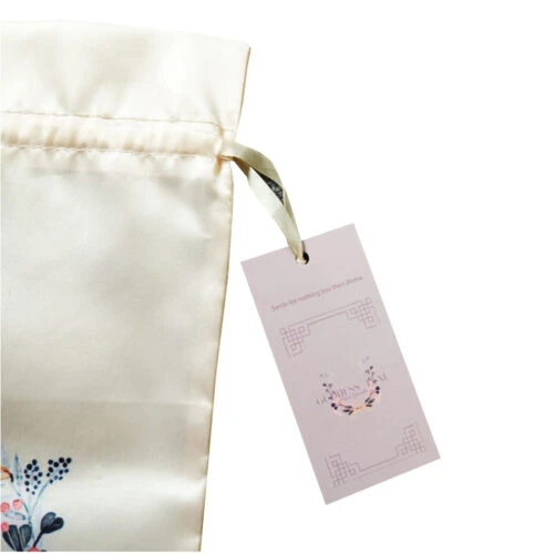 A photo showcasing a custom clothing hang tag. The hang tag features the brand name, logo, and other customized information.