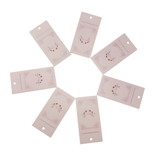 A photo showcasing a custom clothing hang tag. The hang tag features the brand name, logo, and other customized information.