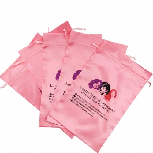 مجموعة من خمسة أكياس وردية اللون من الساتان مع طباعة اسم العلامة التجارية للعميل والبريد الإلكتروني وإنستغرام وفيسبوك عليها.