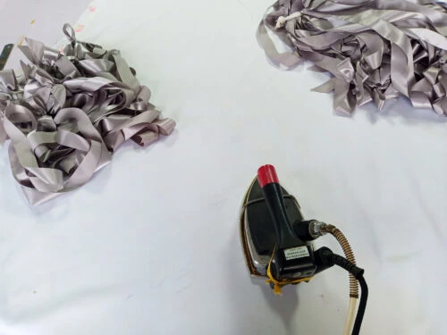 Lazo de cinta plateada que se plancha con una plancha