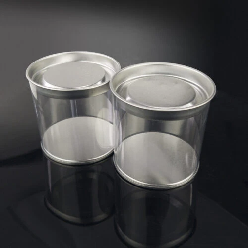 Side view of two plastic tubes with tin lids.