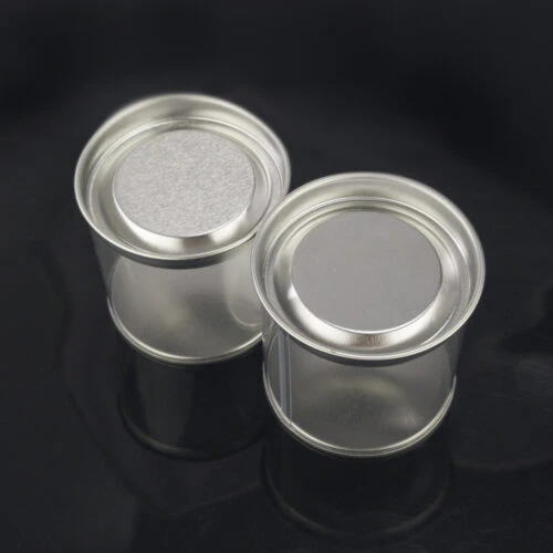Top-down view of two plastic tubes with tin lids.