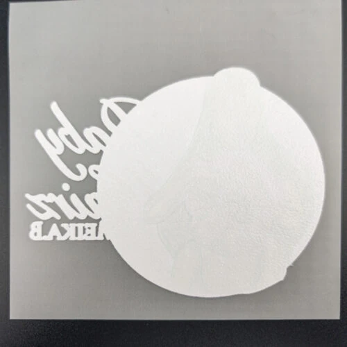 Le dos d'un seul logo découpé dans un film de transfert thermique DTF pleine feuille.