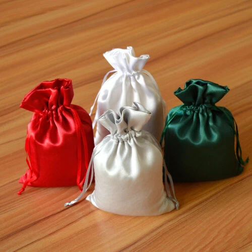 أربع حقائب حريرية مخصصة بألوان مختلفة على سطح خشبي.