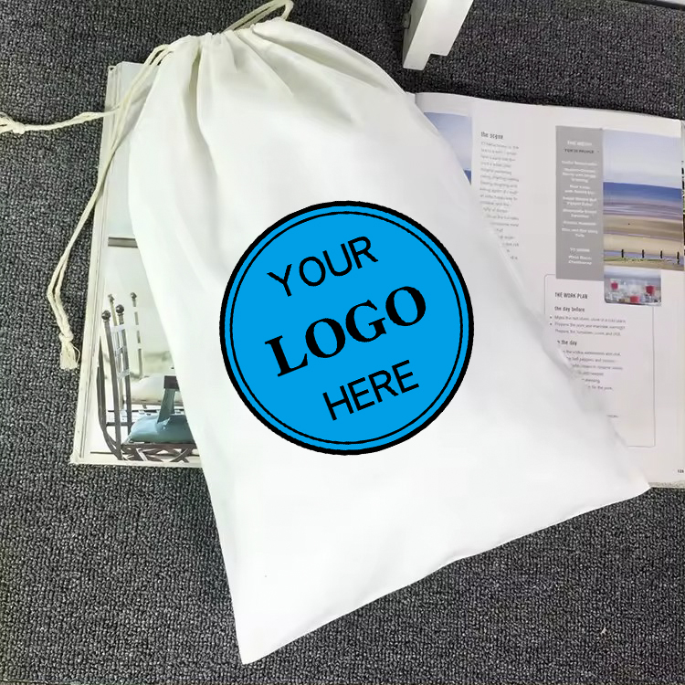 カスタマイズ可能なロゴ入り景品用巾着袋が、開いたパンフレットの横のテーブルに展示されています。