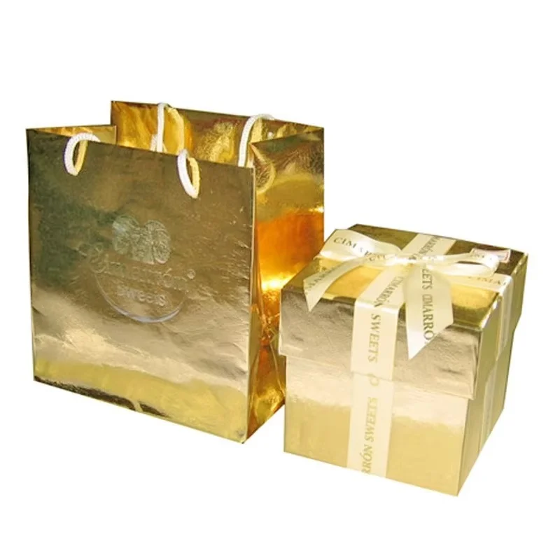 Individuell gestaltetes Set aus Geschenkbox und Papiertüte in Gold mit Schleife, ideal als Geschenk im Einzelhandel.