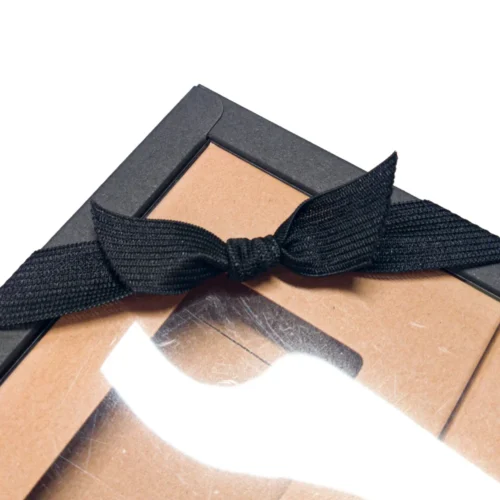 Nœud en ruban élastique tricoté personnalisé sur une boîte cadeau, mettant en valeur son utilisation décorative.