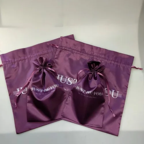 Sacs à perruques en satin personnalisés en violet, conçus pour le rangement des extensions de cheveux avec une fermeture à cordon.
