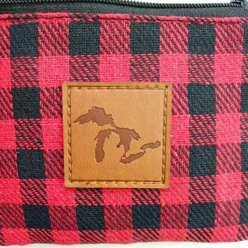 Custom zippered pouch featuring a leather patch with a decorative pattern.