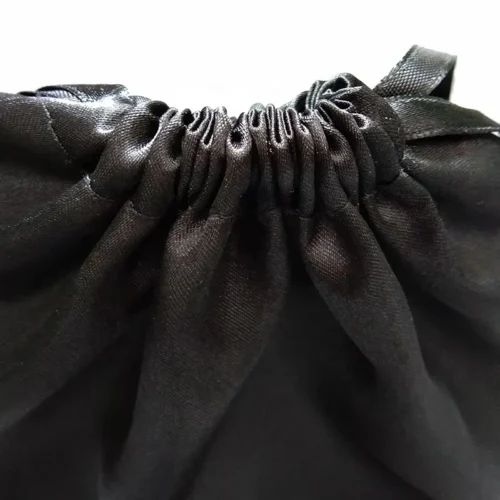 Gros plan d'un sac de maillot de bain personnalisé imperméable à cordon de serrage présentant le haut froncé et le tissu satiné.