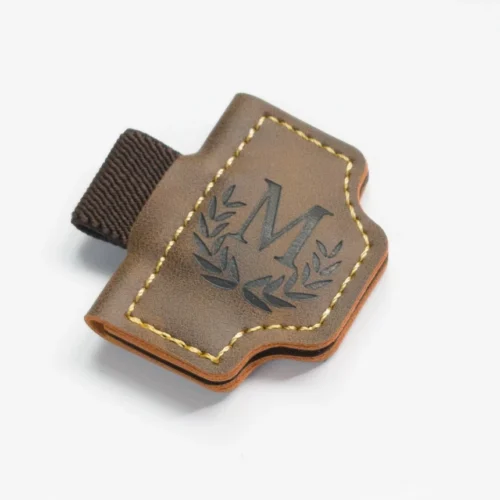 Gros plan sur un marque-page magnétique en cuir marron montrant les coutures et sa construction en couches.