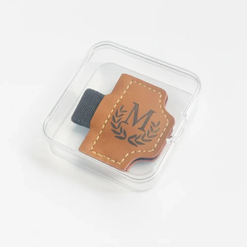 Échantillon de marque-page magnétique en cuir présenté dans un coffret transparent avec un passant élastique pour stylo.
