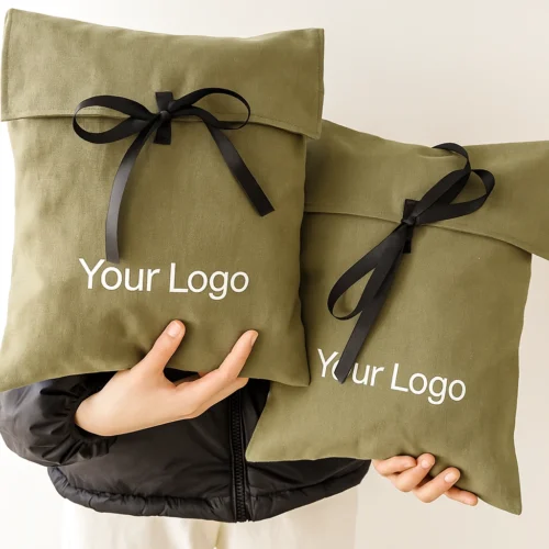 Hand-held olive green custom fold over pouches with ribbon ties, shown as product mockups for scale.