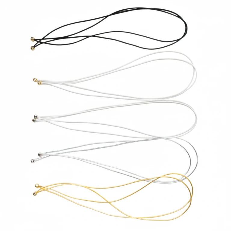 Variedad de muestras de cordón elástico para menús con bola de metal en varios colores, incluyendo negro, blanco, plateado y dorado, que demuestran la seguridad de las sujeciones de las cuentas.
